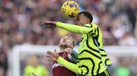 Bek tengah Arsenal, Gabriel Magalhaes memenangkan duel udara dengan Jarrod Bowen dalam laga lanjutan Premier League 2023/2024, di London Stadium, Minggu (11/2/2024) malam WIB. (AP Photo/Ian Walton)