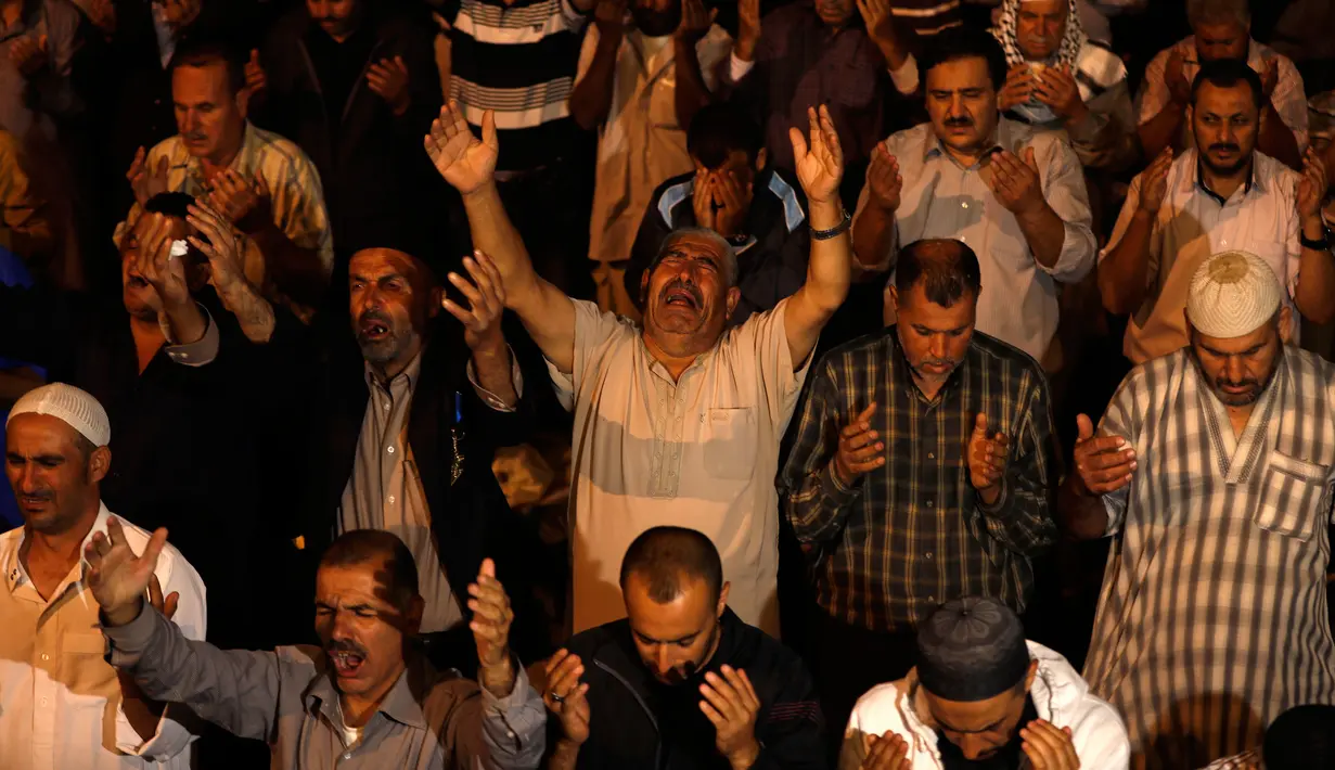 Muslim Palestina memanjatkan doa sambil menunggu Lailatul Qadar di luar Dome of the Rock, kompleks masjid Al-Aqsa di Kota Tua Yerusalem, Senin (11/6).Malam Lailatul Qadar juga disebut malam yang lebih baik daripada malam seribu bulan. (AFP/AHMAD GHARABLI)
