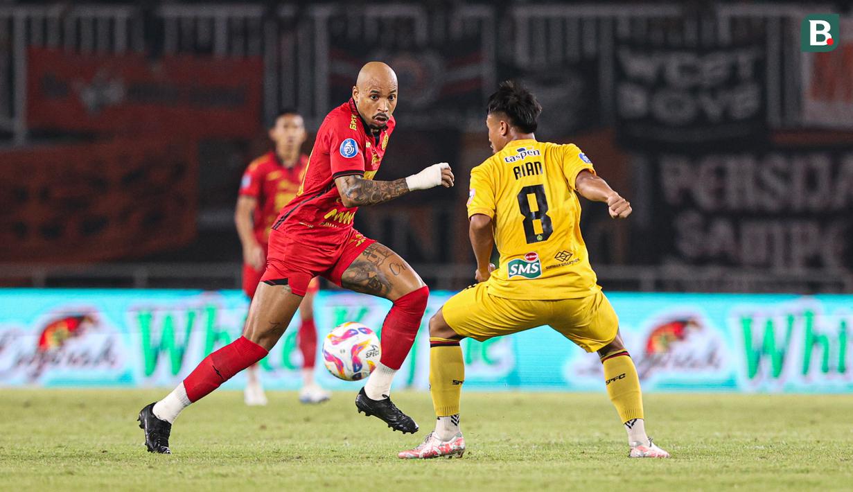 Pemain Persija Jakarta, Gustavo Almeida mencoba melewati pemain Semen Padang Ricki Ariansyah pada laga pekan ke-30 Liga 1 2024/2025 di Stadion Pakansari, Kabupaten Bogor, Minggu (27/4/2025). (Bola.com/Abdul Aziz)