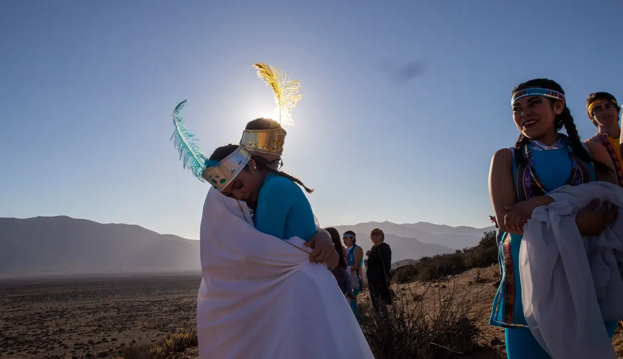 Gadis berpakaian seperti Putri Matahari dan Putri Bulan tiba untuk mengambil bagian dalam sesi foto sebelum gerhana matahari total di La Higuera, Chile (1/7/2019). Turis dan ilmuwan akan berkumpul di Chile utara, salah satu tempat terbaik di dunia untuk menyaksikan gerhana. (AP Photo/Esteban Felix)