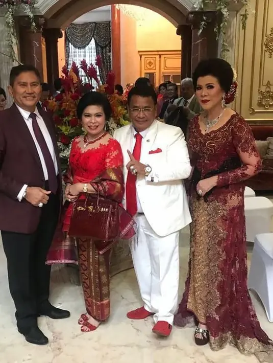 "Siapa bilang aku buaya darat? Aku tinggalin kasus bisnis kakap di jakarta demi temanin istri ke pesta adat! Foto dgn sepupu Tn & Ny Maja hutapea pengusaha bis makmur medan!," tulis Hotman. (Instagram/hotmanparisofficial)
