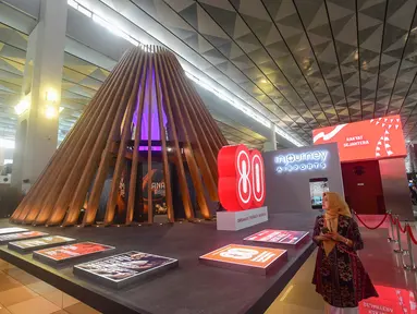 Calon penumpang melihat instalasi arsitektur Nusantara Heritage bertajuk "Tanah Api, Jejak Jiwa” di Terminal 3 Bandara Soekarno-Hatta, Tangerang, Banten, Kamis (14/8/2025). (merdeka.com/Arie Basuki)