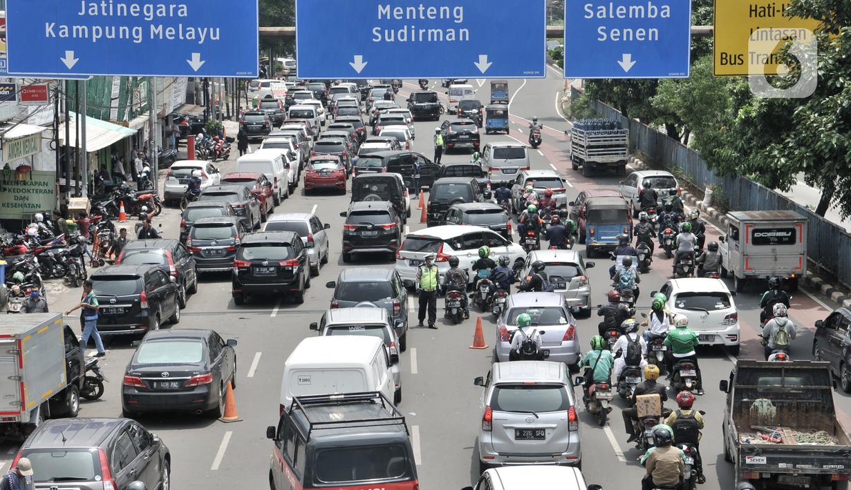 Petugas kepolisian mengatur lalu lintas di depan Pasar Pramuka, Jakarta, Senin (16/3/2020). Pasar Pramuka diserbu pembeli yang mencari masker guna mengantisipasi virus Corona, membuat sebagian badan jalan dimanfaatkan sebagai parkiran sehingga menyebabkan kemacetan. (merdeka.com/Iqbal Nugroho)