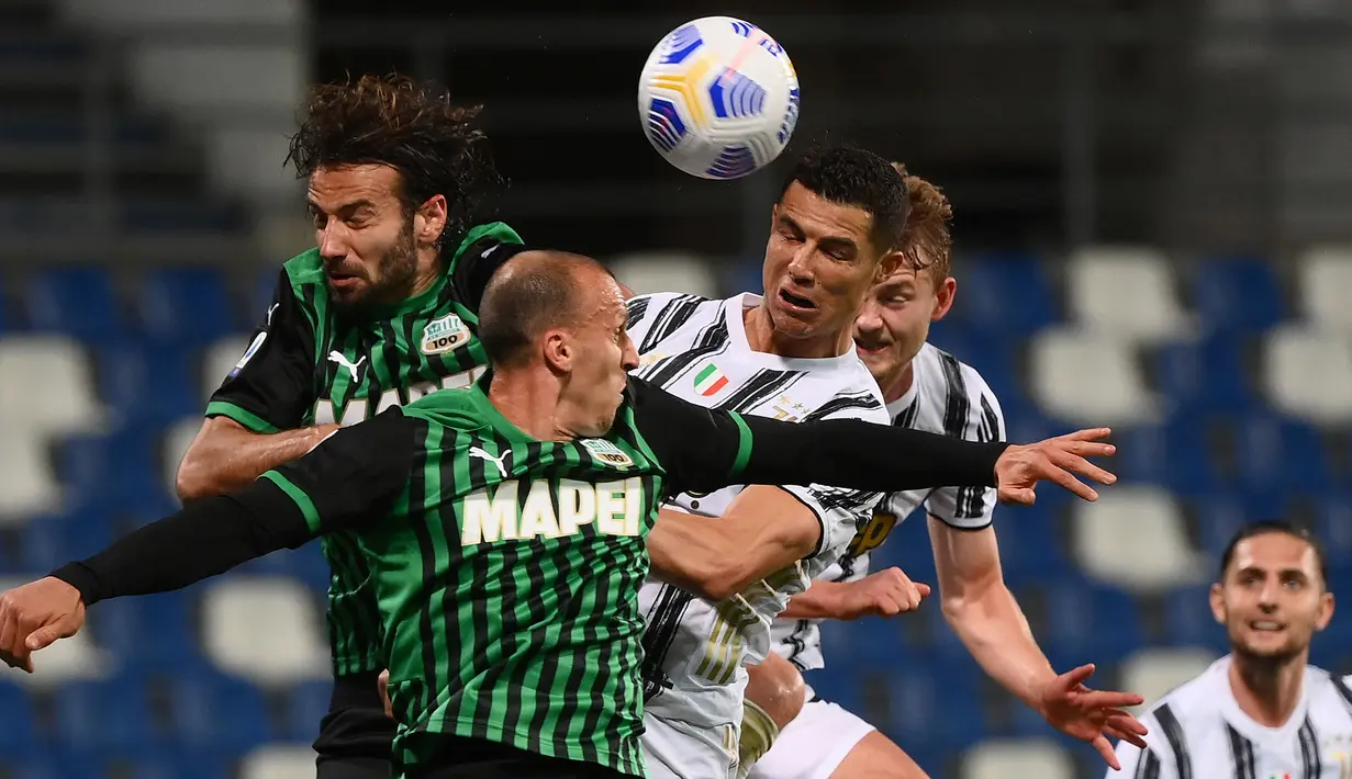 Striker Juventus, Cristiano Ronaldo (kanan) berduel udara dengan bek Sassuolo, Vlad Chiriches dalam laga lanjutan Liga Italia 2020/2021 pekan ke-36 di Mapei-Citta del Tricolore Stadium, Rabu (12/5/2021). Juventus menang 3-1 atas Sassuolo. (AFP/Marco Bertorello)