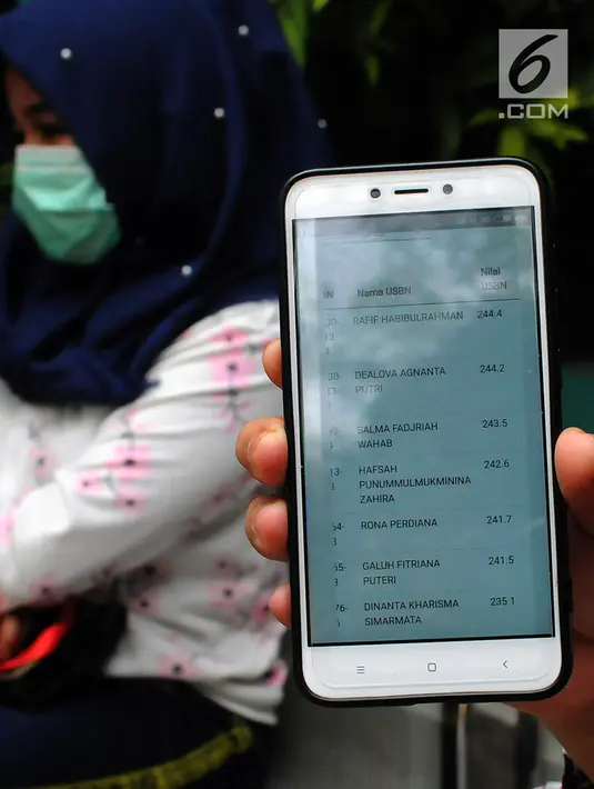 Orang tua wali murid menunjukkan aplikasi situs PPDB Kota Tangsel di posko SMP 11 di Rawa Buntu, Serpong, Tangsel, Jumat (13/07). Orang tua wali murid protes karena situs Penerimaan Peserta Didik Baru (PPDB) yang eror. (Merdeka.com/Arie Basuki)