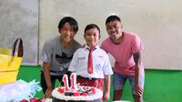 Dua pemain Arema FC, Renshi Yamaguchi dan Kushedya Hari Yudo memberikan kejutan ulang tahun kepada Alfiansyah. (Bola.com/Iwan Setiawan)