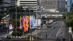 Sebuah mobil melintasi jalan protokol (Medan Merdeka Barat dan Thamrin), Jakarta, Rabu (22/4/2015). Sejumlah ruas jalan utama di Jakarta ditutup untuk sementara saat puncak Konferensi Asia-Afrika (KAA). (Liputan6.com/Faizal Fanani)