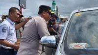 Wakapolresta Banyuwangi AKBP  Dewa Putu Eka Darmawan, bersama pihak ASDP Ketapang membagikan air mineral kepada para penumpang di dalam kendaraan (Istimewa)