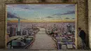 Seniman jalanan Australia James Cochran, berpose untuk mendemonstrasikan efek 3D dari bingkai yang dia lukis agar sesuai dengan tembok bata setelah selesai bekerja membuat mural lanskap kota London di dinding Network Rail oleh Blackfriars Station, di London (5/10/2020). (AP Photo/Matt Dunham)