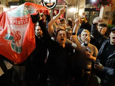 Pendukung Liverpool bernyanyi dan melambai-lambaikan bendera tim mereka di sebuah pub di alun-alun Campo de 'Fiori Roma, Italia (1/5). Liverpool akan menghadapi AS Roma di leg kedua semifinal Liga Champions. (AP Photo/Andrew Medichini )