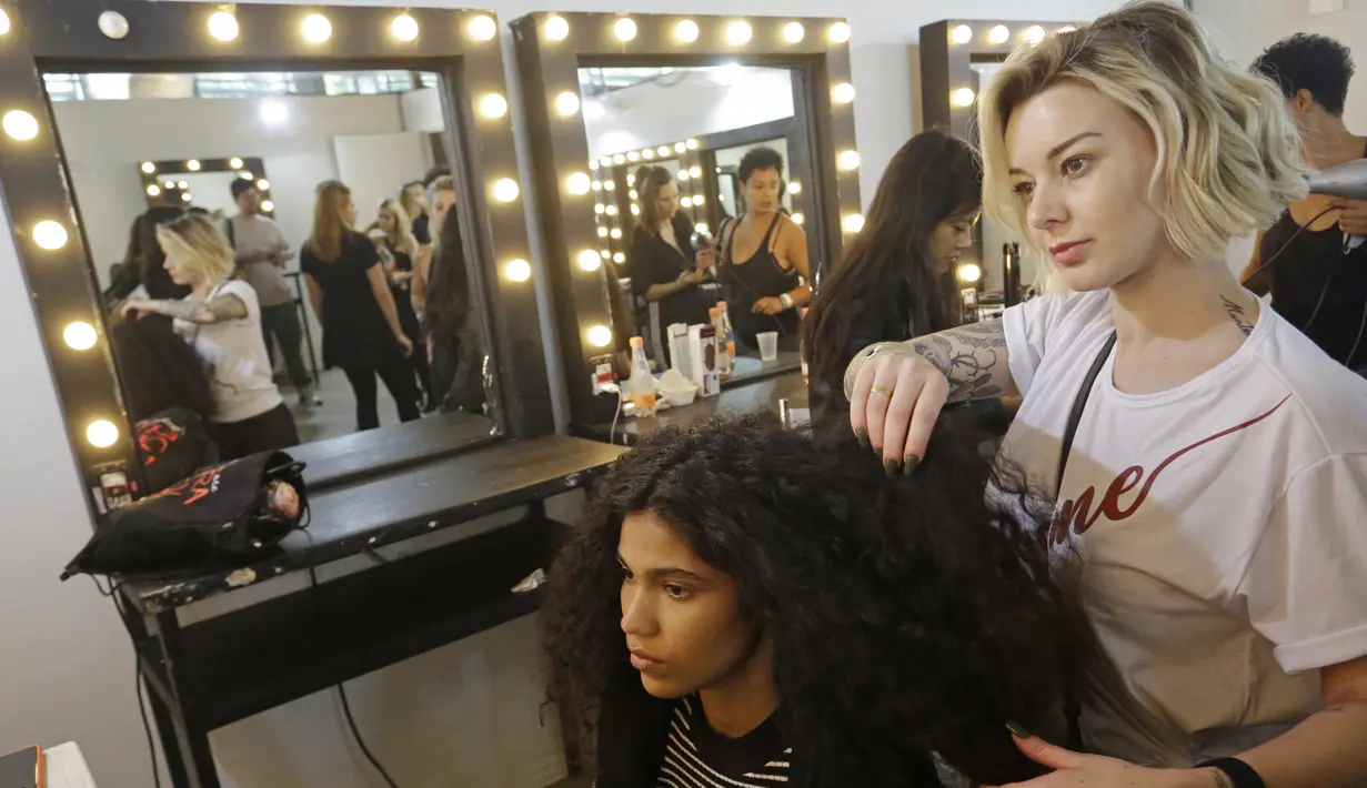 Model saat ditata rambutnya di belakang panggung sebelum tampil membawakan busana koleksi Beira selama Sao Paulo Fashion Week di Sao Paulo, Brasil (16/10/2019). SPFW ke-48 akan berlangsung hingga 18 Oktober.  (AP Photo / Nelson Antoine)