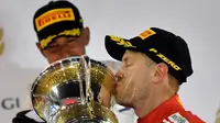 Pebalap Ferrari, Sebastian Vettel, meraih podium juara pada F1 GP Bahrain di Bahrain International Circuit, Minggu (8/4/2018). (AFP/GIUSEPPE CACACE)
