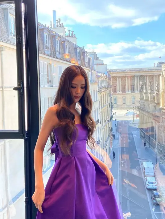 Jisoo Blackpink berpose mengenakan gaun ungu saat bersiap hadir di Dior Paris Fashion Show 2023. Gaun ungu strapless itu dari koleksi Dior. Gaun berpotongan A-line dan flowy juga memiliki hiasan pita di bagian belakang.  (Instagram/sooyaaa__)