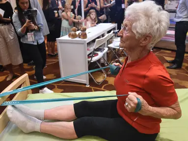 Pesenam tertua di dunia asal Jerman, Johanna Quaas (92) menunjukkan latihan penguatan di tempat tidur khusus untuk orang tua saat Forum Inovasi Aging Asia Internasional ke-8 di Singapura, Selasa (25/4). (AFP PHOTO / ROSLAN RAHMAN)