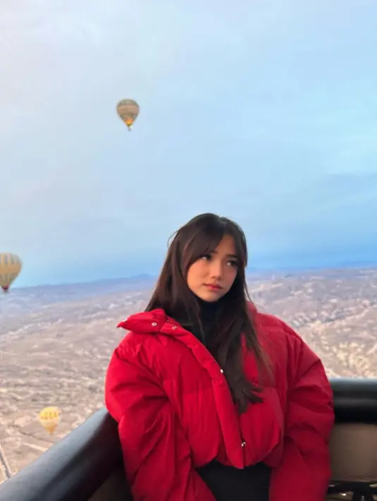 Naik balon udara, Fuji tampil chic mengenakan turtleneck hitam yang ditumpuknya mengenakan cropped puffer jacket berwarna merah. [Foto: Instagram/fuji_an]