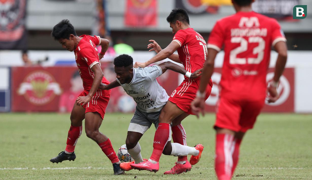 Pemain Persija, Firza Andika (kiri) dan Hanif Abdurrauf Sjahbandi (kanan), berduel dengan pemain Bali United, Jean Marie Privat Befolo Mbarga (tengah), dalam lanjutan BRI Liga 1 di Stadion Patriot Candrabhaga, Bekasi. Minggu (15/1/2023). (Bola.com/Arief Bagus)