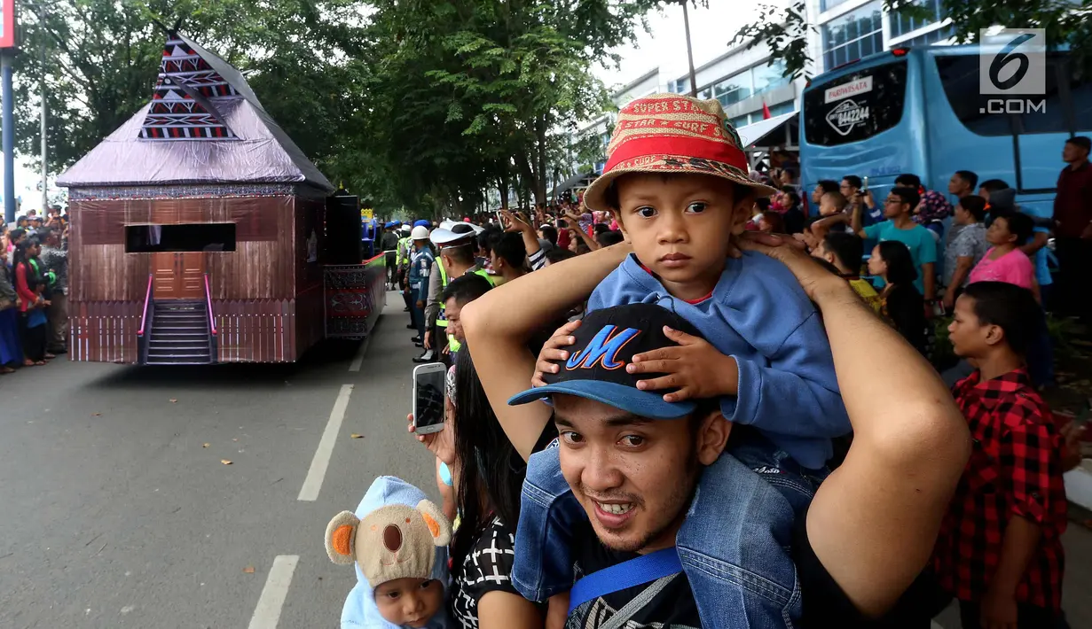 Sejumlah warga menyaksikan kirab resepsi pernikahan Kahiyang Ayu-Bobby Nasution di Kota Medan, Sumatera Utara, Minggu (26/11). (Liputan6.com/Johan Tallo)