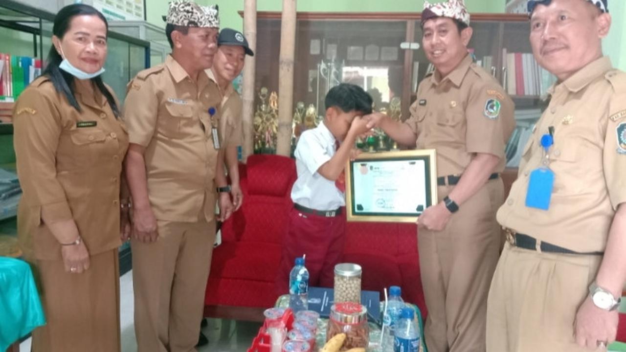 Kepala Dinas Pendidikan Banyuwangi Surtno menyerahkan penghargaan berupa golden tiket masuk SMP kepada penyanyi cilik asal Banyuwangi Farel Prayoga (Istimewa)
