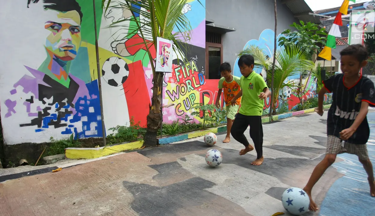 Anak-anak bermain bola di sebuah gang di Kinayungan, Tangsel, Kamis (28/6). Warga di perumahan tersebut menghias lingkungannya menjadi "Kampung Piala Dunia" guna menyemarakan perhelatan sepak bola Piala Dunia 2018 di Rusia. (Merdeka.com/ Arie Basuki)