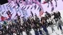 Pembawa bendera Amerika Serikat Sue Bird (kedua kanan) dan Eddy Alvares memimpin delegasi saat upacara pembukaan Olimpiade Tokyo 2020, di Olympic Stadium di Tokyo, Jumat (23/7/2021). Upacara pembukaan Olimpiade Tokyo yang berlangsung dalam era pandemi digelar tanpa penonton. (Jeff PACHOUD / AFP)