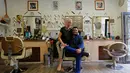 Ibrahim Haji Mohammad bersama sang istri Krisztina berpose berpose di dalam toko tempat cukur miliknya di Budapest, Hongaria, 24 Mei 2016. (REUTERS / Laszlo Balogh)
