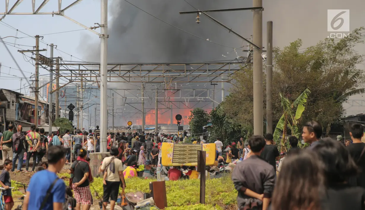 Sejumlah orang berkerumun melihat kebakaran yang melanda ratusan rumah semi permanen atau bedeng di belakang Hotel Alexis, Pademangan, Jakarta, Sabtu (16/9). Untuk memadamkan api, sebanyak 20 mobil Damkar dikerahkan. (Liputan6.com/Faizal Fanani)