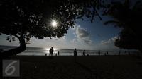 Sejumlah wisatawan menikmati terik matahari di kawasan Pantai Kuta, Bali, 31 Agustus 2015. Pantai Kuta masih menjadi lokasi wisata utama bagi wisatawan yang berkunjung ke Bali. (Liputan6.com/Helmi Fithriansyah)