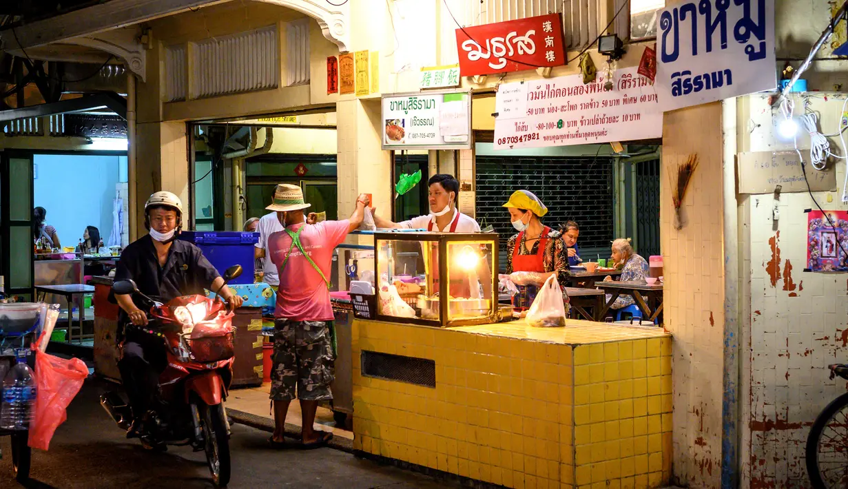 Seorang pria mengendarai sepeda motornya di Chinatown Bangkok  (16/9/2020). Chinatown Bangkok awalnya merupakan kawasan hutan belantara di luar tembok kota dan berkembang menjadi pusat komersial Bangkok selama akhir abad ke-19 hingga awal abad ke-20. (AFP/Mladen Antonov)