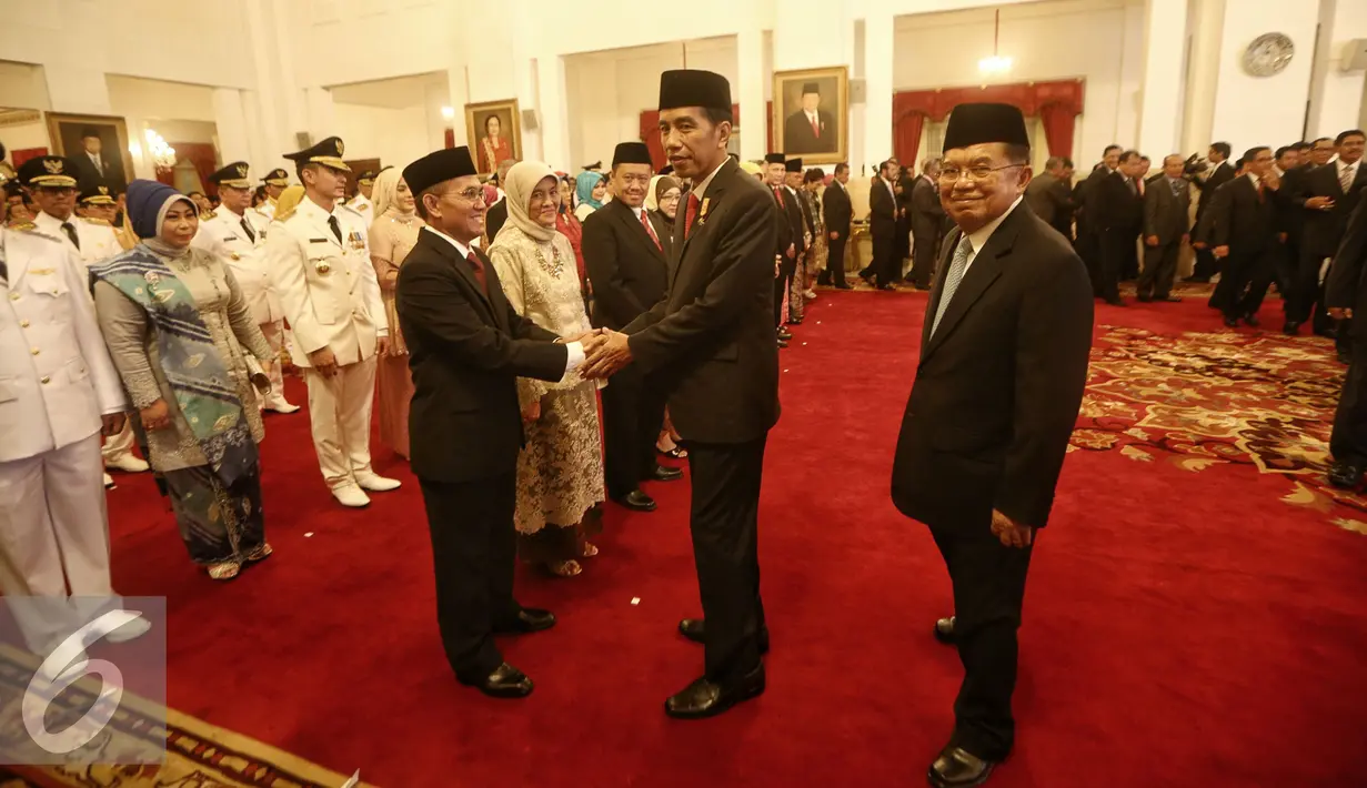 Presiden Joko Widodo berjabat tangan usai melantik dua anggota Komisi Yudisial (KY) dan 9 anggota Ombudsman di Istana Negara, Jakarta (12/2). (Liputan6.com/Faizal Fanani)