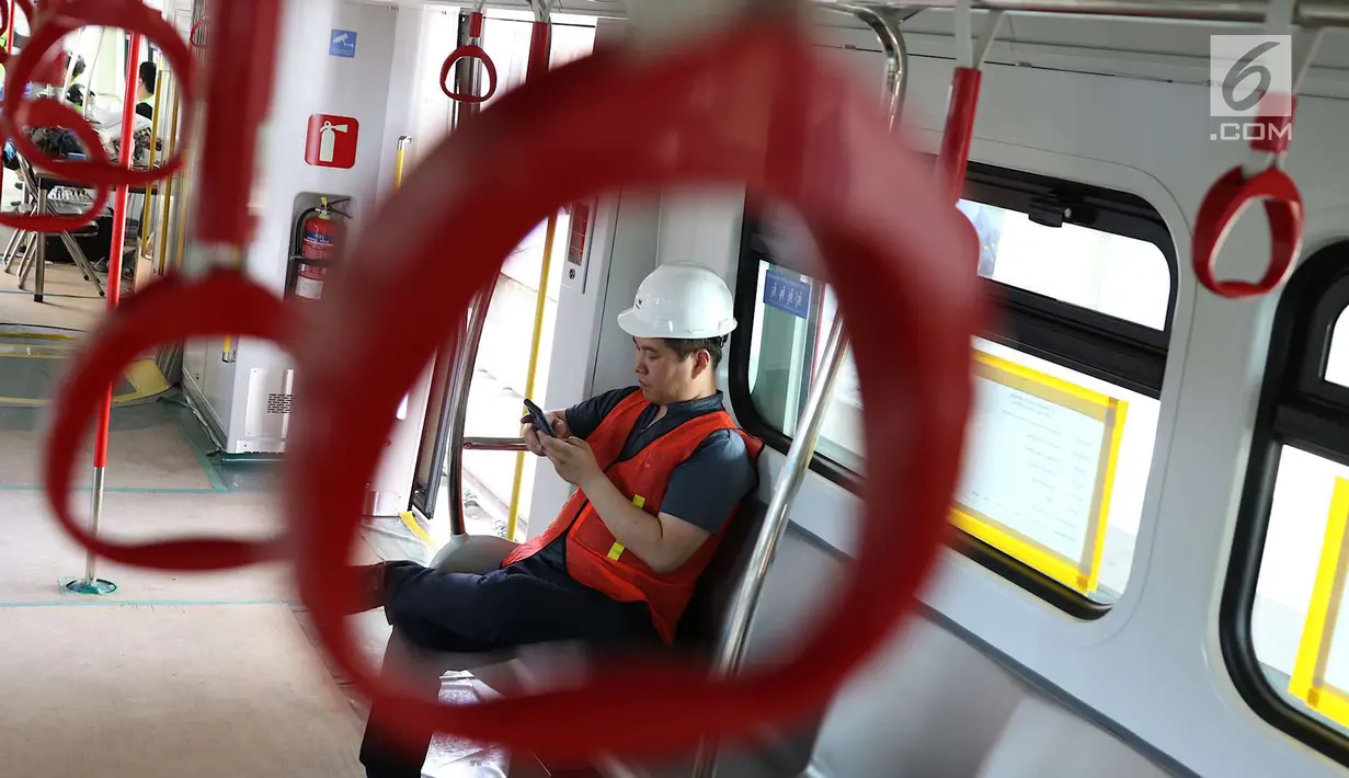 Seorang petugas berada di gerbong kereta Light Rail Transit (LRT) ketika melakukan ujicoba di Kelapa Gading, Jakarta, Kamis (14/6). Kereta LRT diuji coba sejauh 1,1 kilometer dengan kecepatan 80 km per jam. (Liputan6.com/Immanuel Antonius)