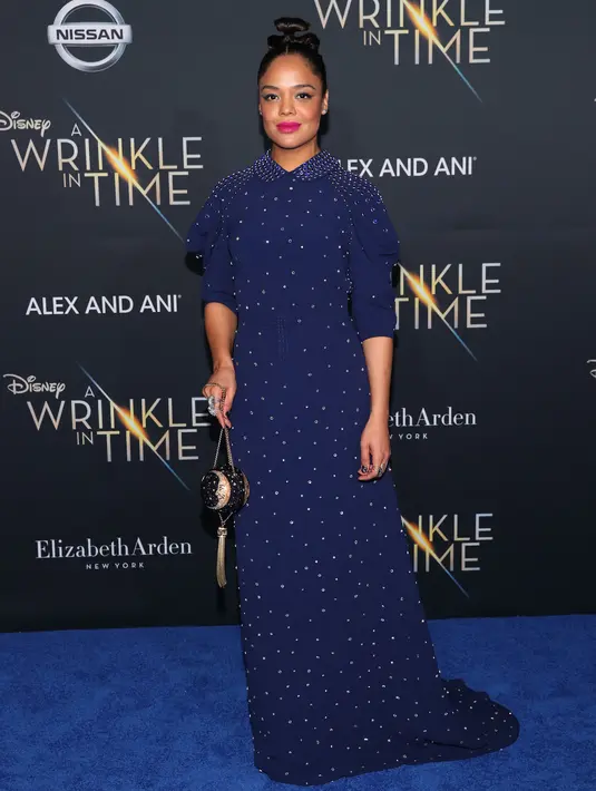 Aktris Tessa Thompson menghadiri premier film "A Wrinkle In Time" di Los Angeles, Senin (26/2). Tessa Thompson memadukan gaun malamnya dengan hairbun effortless serta lipstik hot pink dan cat-eyeliner yang dramatis. (Christopher Polk/GETTY IMAGES/AFP)