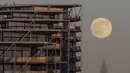 The Wolf Moon, bulan purnama pertama tahun ini, muncul di belakang The Shard di pusat kota London, Senin (17/1/2022). Wolf Moon atau disebut juga Bulan purnama Serigala adalah sebutan untuk bulan purnama pertama di Januari. (Justin TALLIS / AFP)
