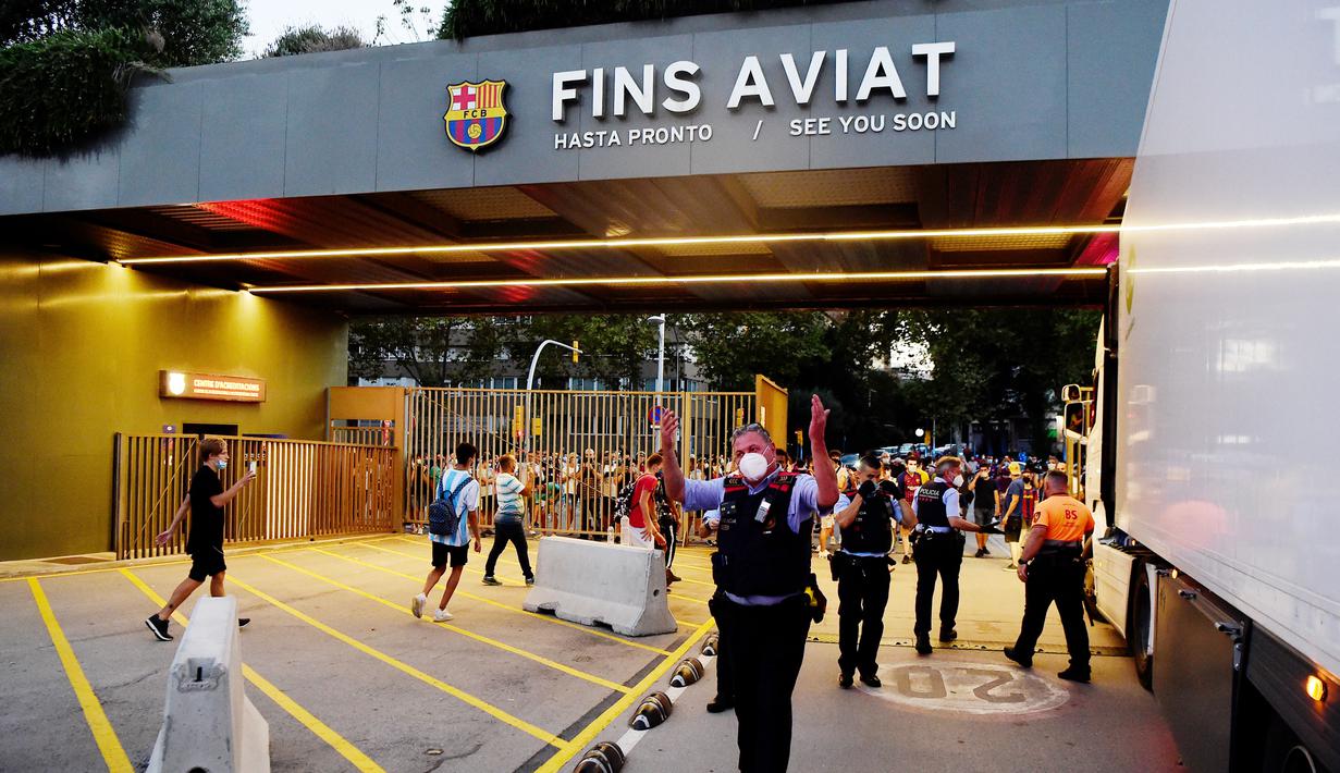 Petugas keamanan berusaha menghalau suporter yang menerobos kantor Barcelona, Rabu (26/8/2020). Dalam aksi tersebut fans meminta Lionel Messi bertahan dan menuntut Josep Maria Bartomeu mundur dari jabatannya. (AFP/Pau Barrena)