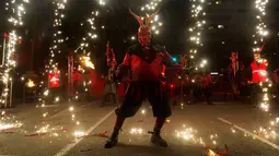 Peserta bersuka ria ambil bagian dalam festival tradisional Correfoc di Palma de Mallorca, Spanyol, Senin (21/1). Para peserta berkostum setan dan iblis berjalan-jalan sambil menakuti orang-orang dengan api dan kembang api. (JAIME REINA/AFP)