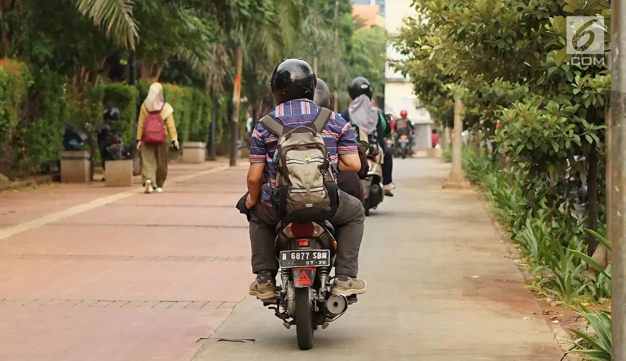 Pengendara sepeda motor melintasi trotoar di kawasan Menteng Pulo, Jakarta, Selasa (14/5/2019). Kemacetan yang semakin parah di Ibu Kota menyebabkan para pemotor nekat menerobos trotoar dan merampas hak pejalan kaki. (Liputan6.com/Immanuel Antonius)