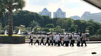 Penyandang disabilitas netra jalan kaki sambil berpegangan satu sama lain di kawasan Masjid Istiqlal, Jakarta Pusat. Foto: Ade Nasihudin.