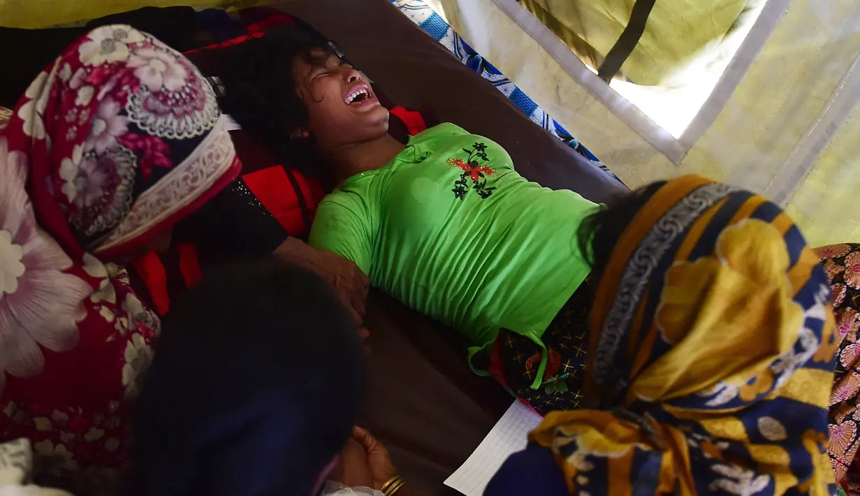 Seorang wanita Rohingya bernama Hasina Aktar bereaksi saat melahirkan di sebuah pusat medis di kamp pengungsian Kutupalong (11/10). Anak Hasina Aktar ini diberi nama Mohammed Jubayed. (AFP Photo/Munir Uz Zaman)