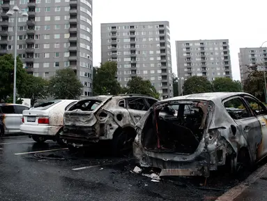 Deretan mobil yang terparkir di kota Gothenburg, Swedia hangus dan rusak, Selasa (14/8). Sekelompok orang bertopeng dan berpakaian hitam dilaporkan menjadi pelaku pembakaran puluhan mobil di sejumlah kota dalam semalam. (Adam Ihse/TT via AP)