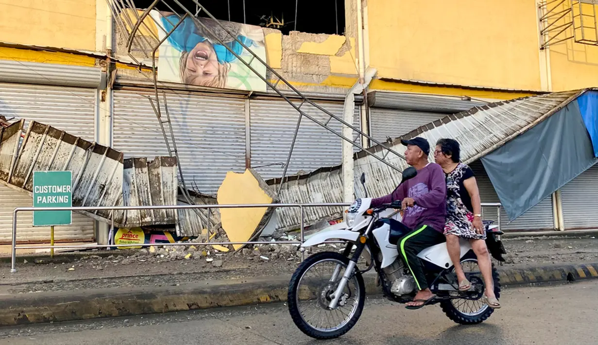 Sebuah sepeda motor melewati toko kelontong yang rusak sebagian akibat gempa di Kota Bayugan, Agusan del Sur, Filipina, Minggu (3/12/2023). Gempa bumi lepas pantai berkekuatan magnitudo 7,4 -- sebelumnya diberitakan sejumlah media bermagnitudo 7,5 dan 7,6 --  yang melanda Filipina selatan pada 2 Desember 2023 malam telah menewaskan satu orang dan melukai dua lainnya, lapor Xinhua pada Minggu (3/12/2023) mengutip otoritas setempat. (AP Photo/Ivy Marie Mangadlao)
