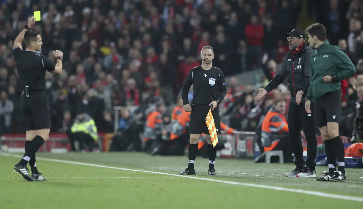 Wasit asal Spanyol Carlos del Cerro Grande (kiri) memberikan kartu kuning ke pelatih Liverpool, Jurgen Klopp pada pertandingan Grup E Liga Champions di stadion Anfield, Inggris (27/11/2019). Liverpool bermain imbang 1-1 atas Napoli. (AP Photo/Jon Super)