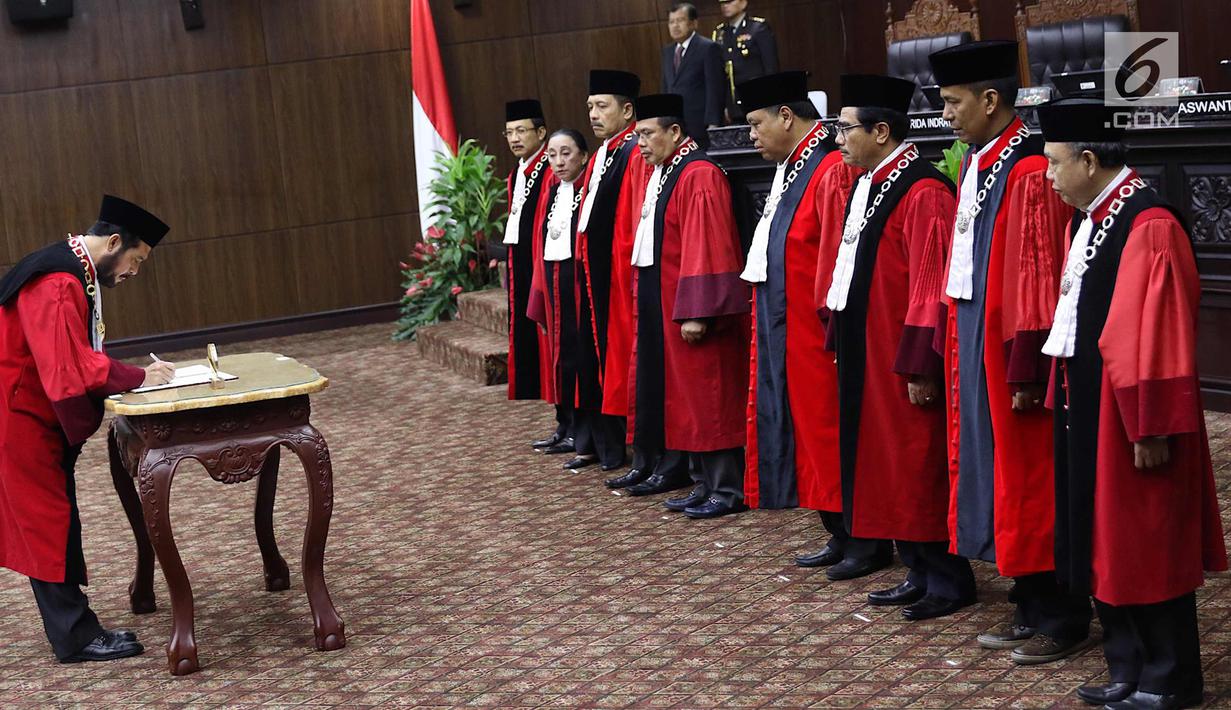 Ketua MK terpilih Anwar Usman menandatangani dokumen usai sumpah jabatan Ketua dan Wakil Ketua MK di gedung MK, Jakarta, Senin (2/4). Anwar dan Aswanto resmi jadi Ketua dan Wakil Ketua MK periode 2018-2020. (Liputan6.com/Immanuel Antonius)
