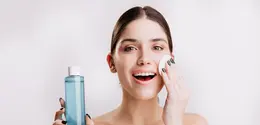 Seorang perempuan sedang membersihkan wajahnya menggunakan micellar water (Foto Dok: Freepik/lookstudio).
