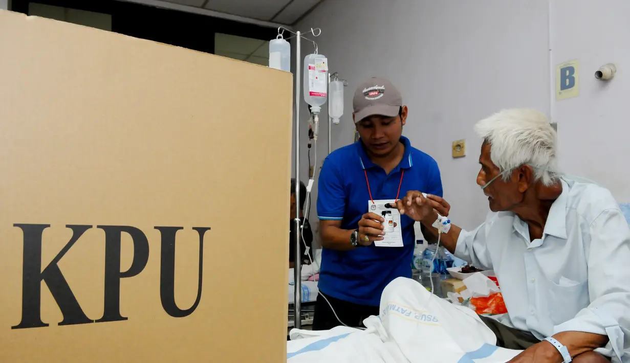 Pasien RS.Fatmawati dibantu petugas KPPS mencelupkan jari kelingkingnya sebagai bukti bahwa pasien tersebut telah menggunakan hak pilihnya di RS.Fatmawati, Jakarta Selatan, Rabu (9/4) (Liputan6.com/Andrian M Tunay)