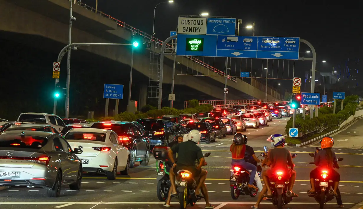 Antrean panjang kendaraan untuk memasuki Woodlands Checkpoint sebelum melintasi jalan lintas ke Malaysia di Singapura, Jumat (1/4/2022). Singapura dan Malaysia kembali membuka perbatasannya untuk semua pelancong yang divaksinasi lengkap. (Roslan RAHMAN/AFP)
