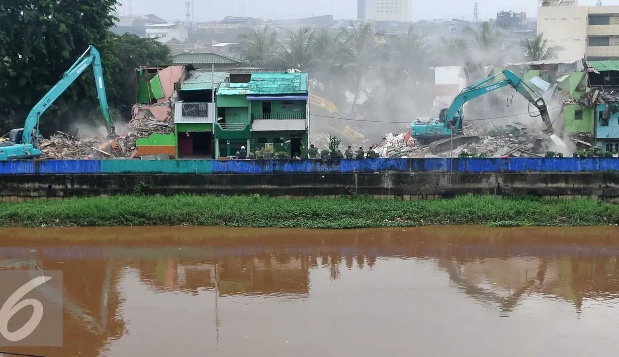 Sejumlah alat berat merobohkan bangunan di kawasan prostitusi Kalijodo, Jakarta Utara, Senin (29/2). Puluhan bangunan di kawasan tersebut mulai rata dengan tanah serta menjadi tontonan warga. (Liputan6.com/Gempur M Surya)