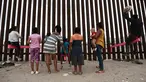 Anak-anak bermain jungkat-jungkit yang dipasang di antara pagar pemisah Meksiko dengan Amerika Serikat, Ciudad de Juarez, Meksiko, Minggu (28/7/2019). Jungkat-jungkit tersebut dirancang seorang profesor arsitektur California, Ronald Rael. (AP Photo/Christian Chavez)