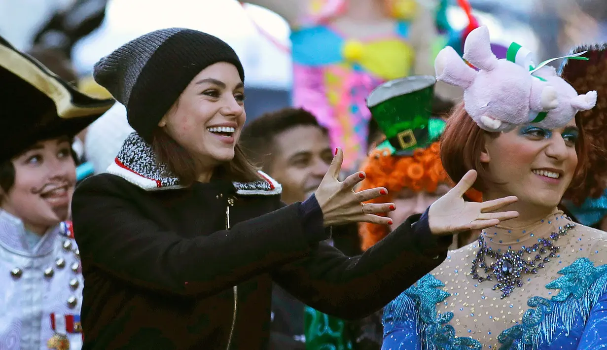 Aktris Mila Kunis menerima boneka saat diarak dalam sebuah parade di Cambridge (25/1). Hasty Pudding sendiri adalah kelompok teater yang berasal dari Universitas Harvard. (AP Photo / Charles Krupa)