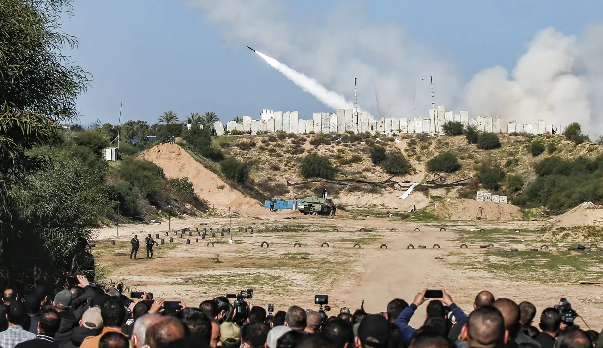 Warga menyaksikan peluncuran rudal dalam latihan perang gabungan di Kota Gaza, Palestina (29/12/2020). Untuk pertama kalinya, Hamas bersama sayap militer kelompok-kelompok perlawanan Palestina lainnya menggelar latihan perang gabungan. (AFP/Mohammed Abed)