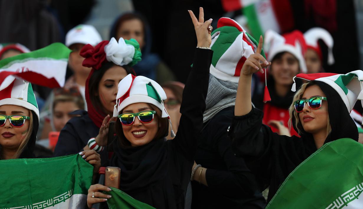 Seorang wanita Iran menunjukkan tanda kemenangan saat menyaksikan laga kualifikasi Piala Dunia 2022 antara Iran dengan Kamboja di Stadion Azadi, Teheran, Iran, Kamis (10/10/2019). Wajah-wajah mereka berlimpah senyuman. (AP Photo/Vahid Salemi)