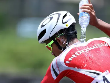 Atlet ParaCycling, M Fadli Immamuddin mengguyur tubuhnya saat laga di nomor Mens C4 Road Race Asian Para Games 2018 di Sirkuit Sentul Bogor, Selasa (9/10). M Fadli menempati posisi keempat. (Liputan6.com/Helmi Fithriansyah)